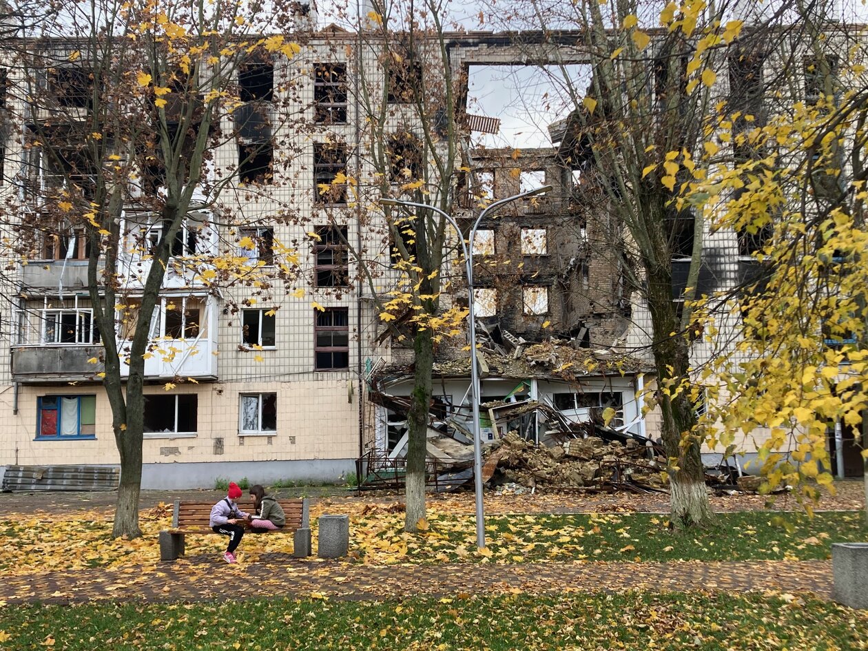 Children play in front of a destroyed multistorey building in Bucha, Ukraine