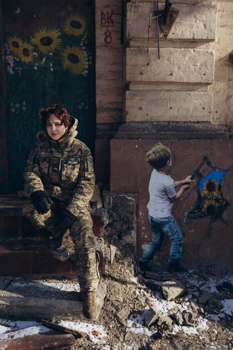 Ukrainian soldier Sarnatska seats at a graffiti